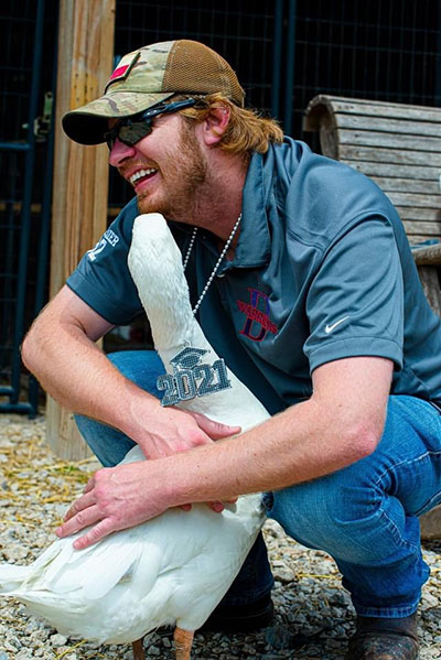 Army veteran and wounded warrior Joel Brasier gets a hug from his friend George. The friendship with the goose inspired Joel to write a children's book.